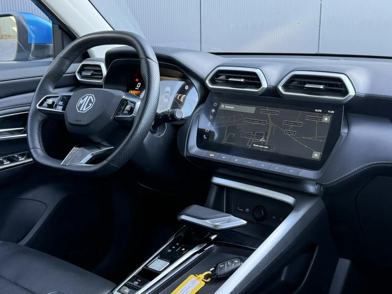 Vue intérieure côté conducteur du MG ZS 1.5 Hybrid+ 197 Luxury 2025, tableau de bord noir avec écran tactile et volant cuir.