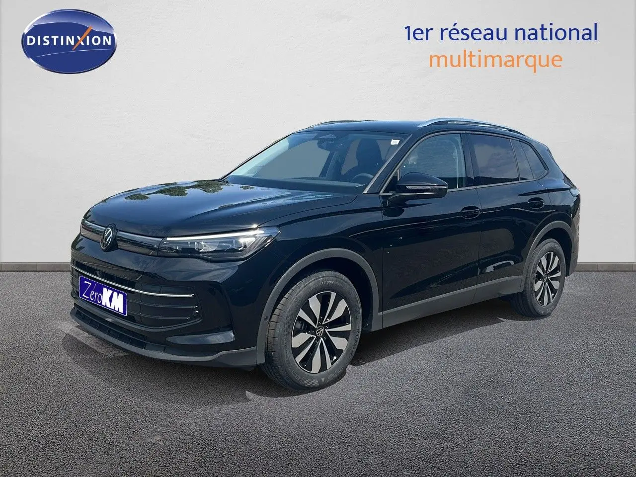 Volkswagen Tiguan noir Grenadilla métal en 3/4 avant droit, avec jantes bicolores et calandre épurée.
