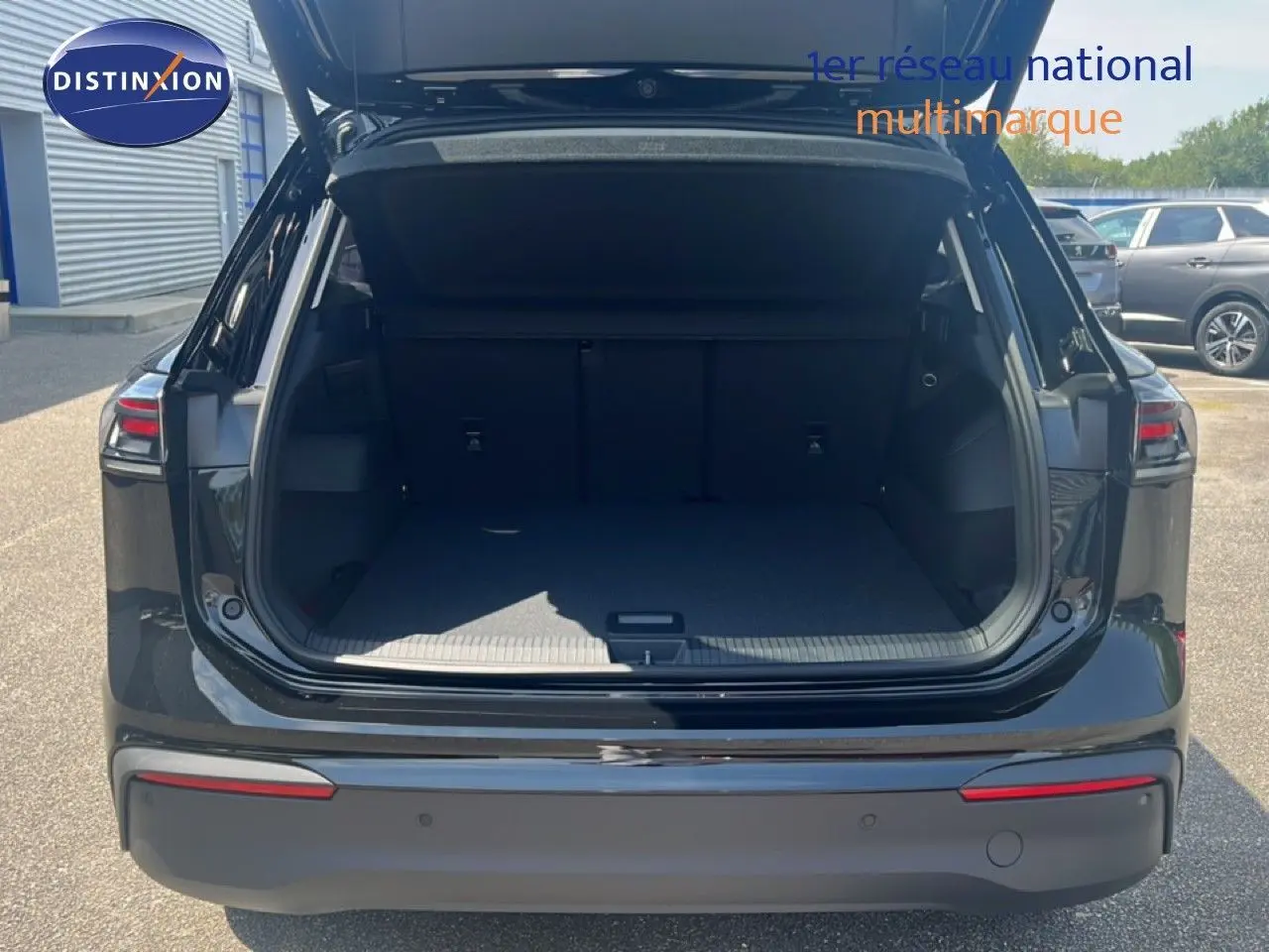 Vue arrière du Volkswagen Tiguan noir Grenadilla avec coffre ouvert, montrant l'espace de chargement vide.