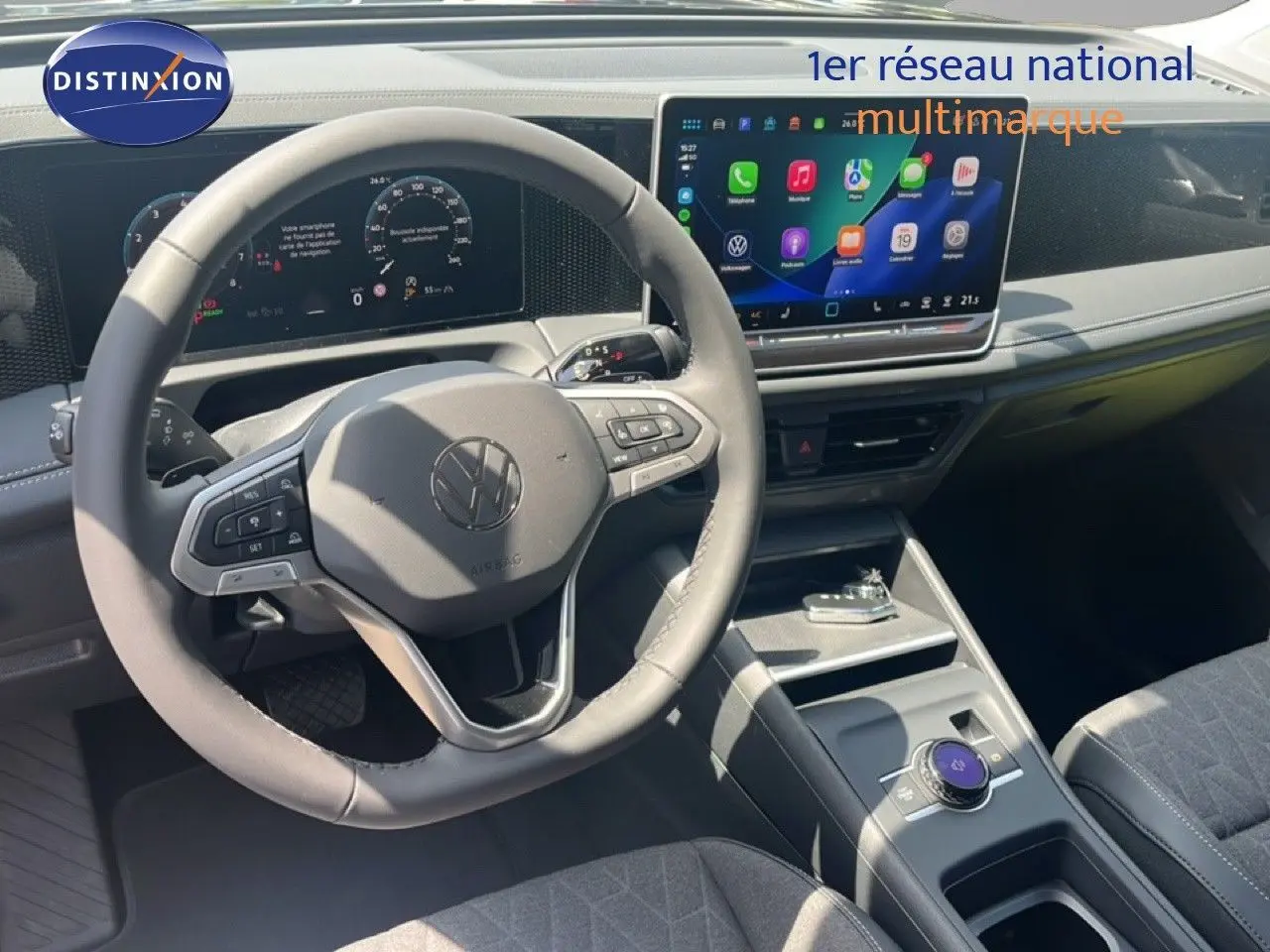Vue intérieure du Volkswagen Tiguan 2026 montrant le volant multifonction et l'écran tactile central lumineux.