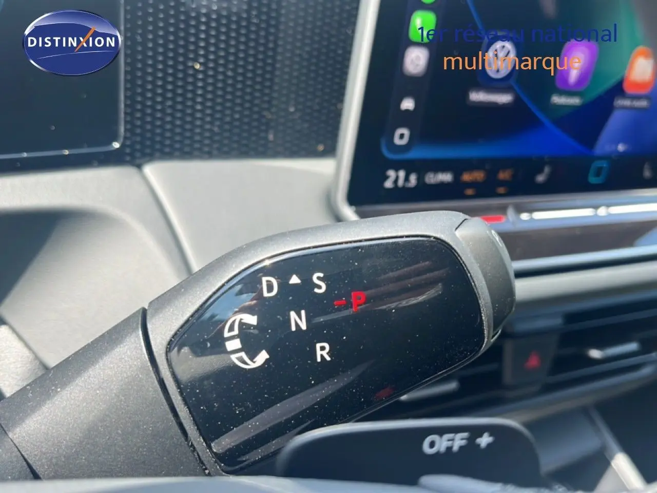 Gros plan sur le levier de vitesses automatique du Volkswagen Tiguan noir Grenadilla, avec écran tactile en arrière-plan.