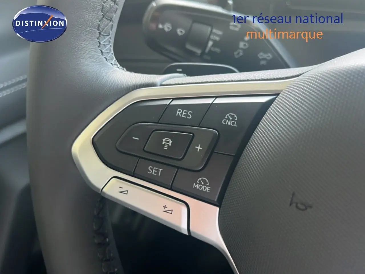 Gros plan sur le volant noir du Volkswagen Tiguan 2026, mettant en valeur les commandes de régulateur de vitesse.
