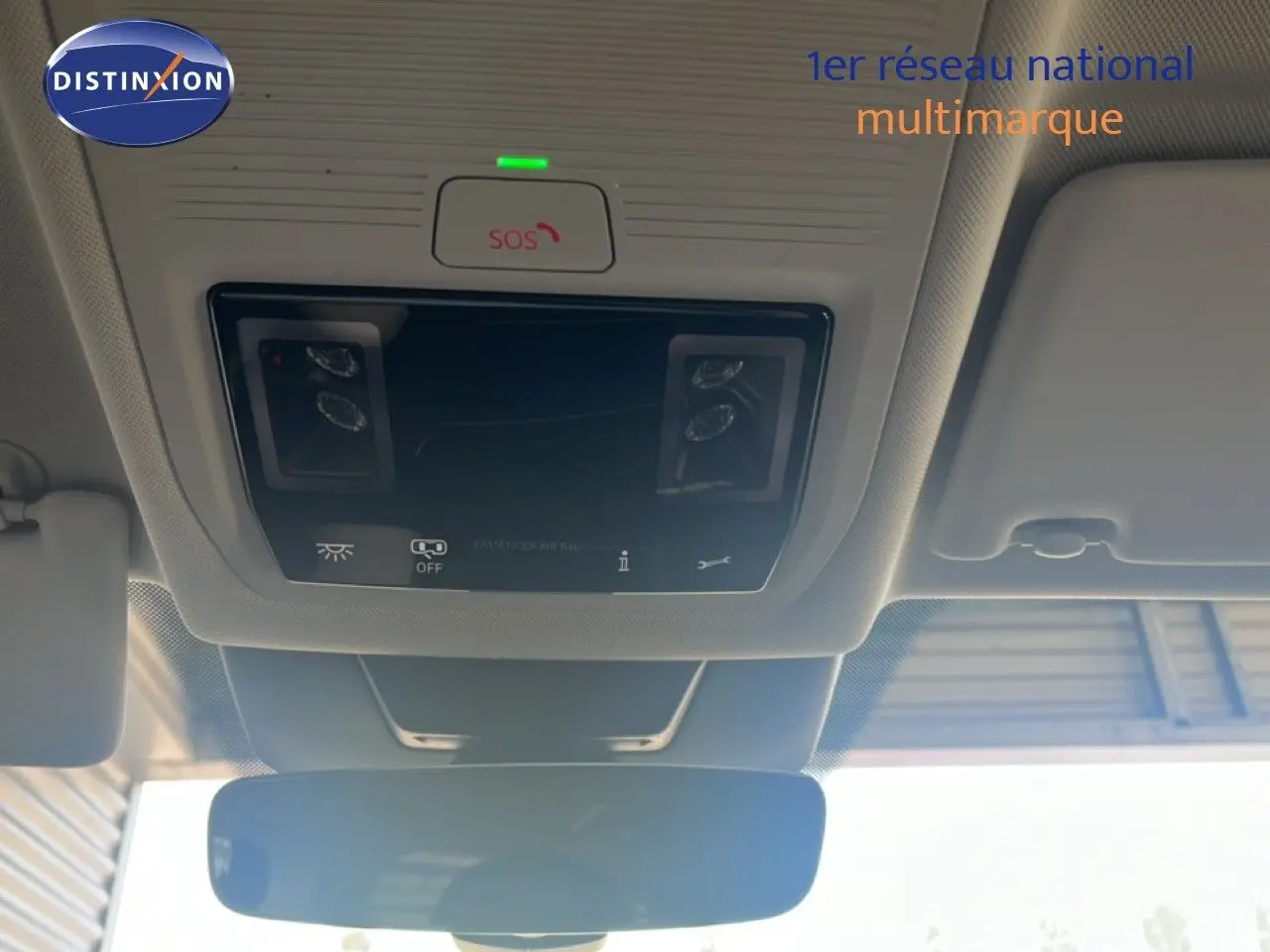 Vue intérieure du plafond avant du Volkswagen Tiguan noir Grenadilla, montrant les commandes d'éclairage et le bouton SOS au-dessus du rétroviseur.
