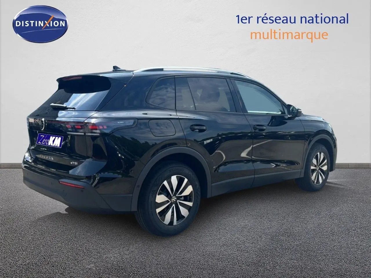 Vue 3/4 arrière droite du Volkswagen Tiguan noir Grenadilla métallisé avec jantes bicolores et toit ouvrant.