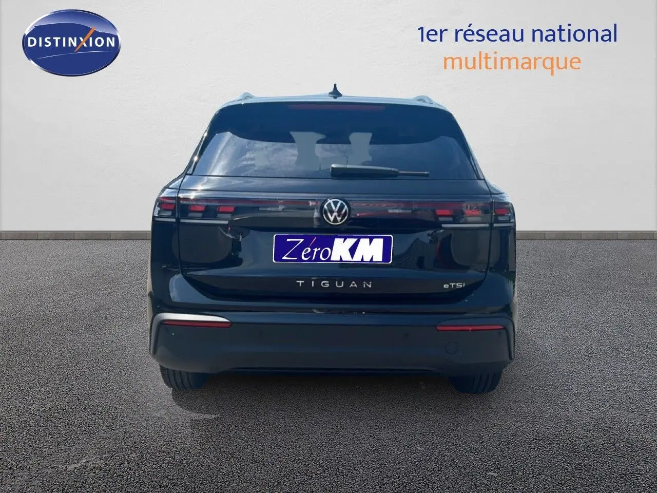 Vue arrière d'un Volkswagen Tiguan noir grenadilla métal, mettant en valeur ses feux arrière étirés et son design épuré.