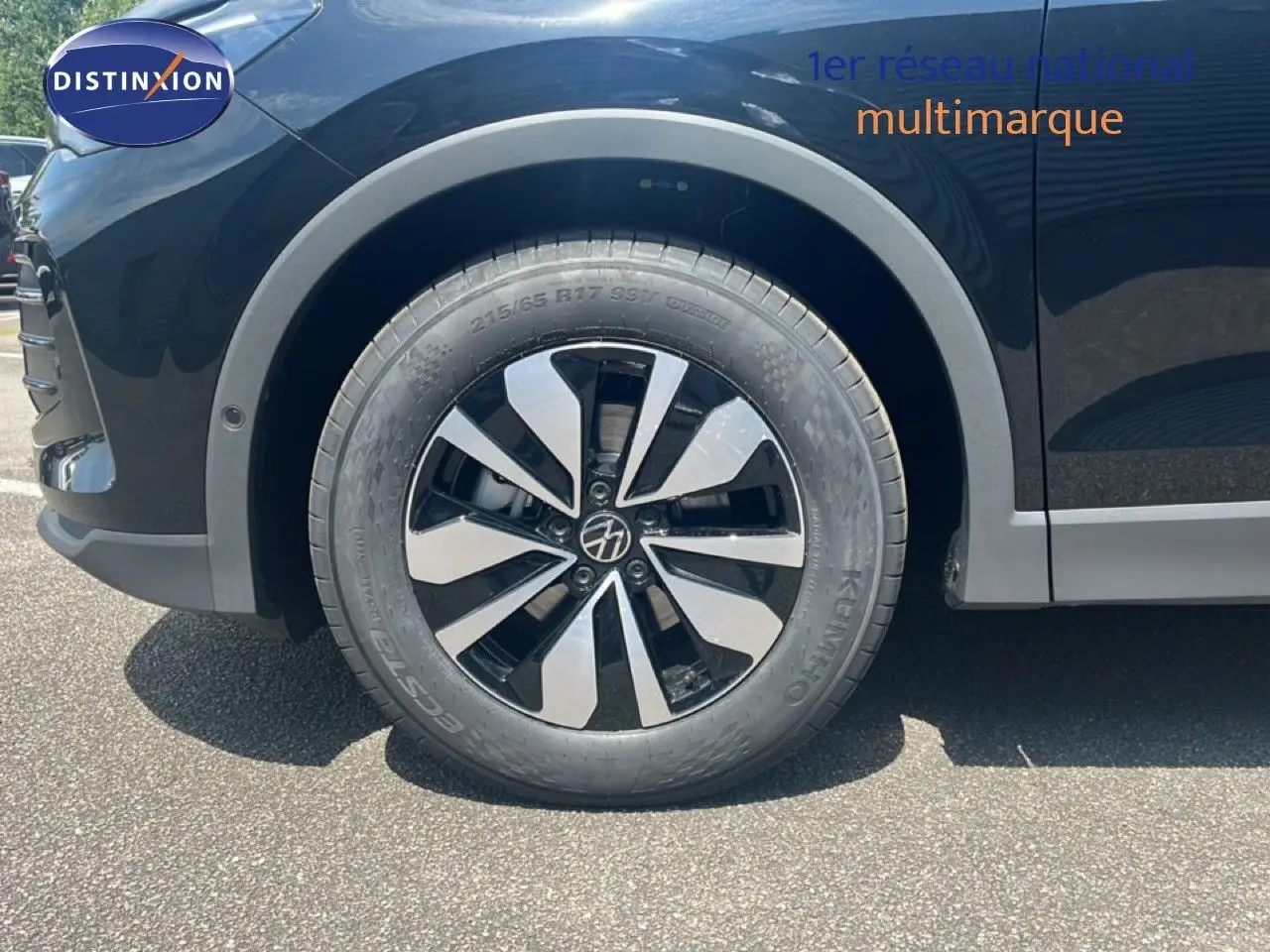 Gros plan sur la roue avant gauche du Volkswagen Tiguan noir Grenadilla, mettant en valeur la jante bi-ton distinctive.