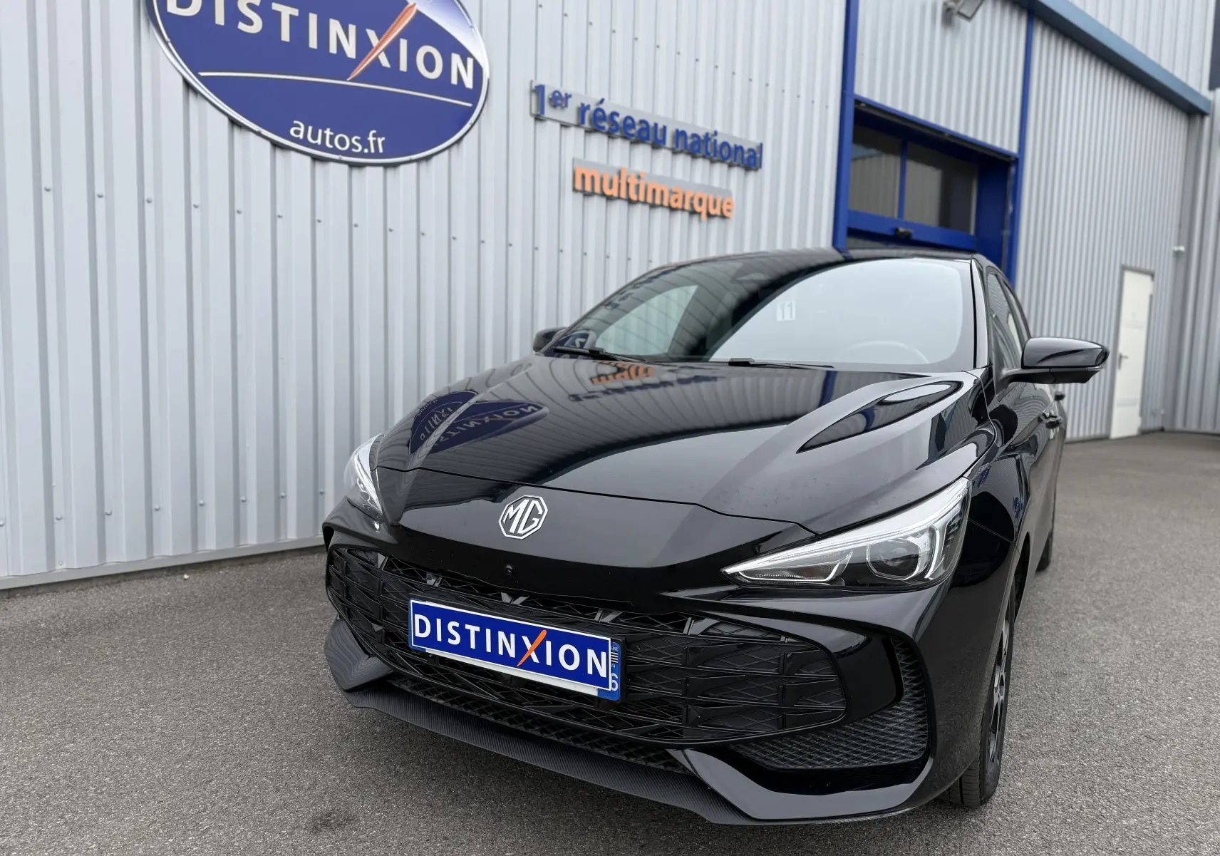 Vue 3/4 avant droite d'une MG3 1.5 HYBRID+ 195 LUXURY noire Pebble Black, avec calandre et phares LED distinctifs.