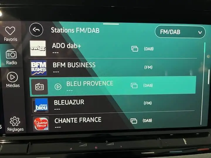 Écran tactile multimédia de Volkswagen Golf 8 en gros plan, affichant les stations radio FM/DAB.