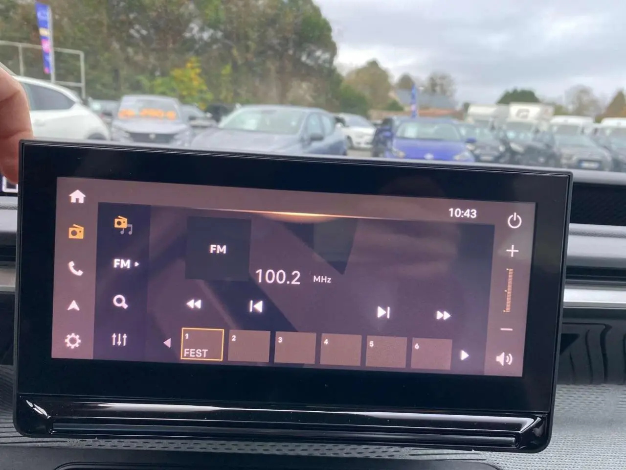 Écran tactile central du tableau de bord du Citroën C3 Aircross 2025, affichant la radio FM 100.2 MHz en extérieur.