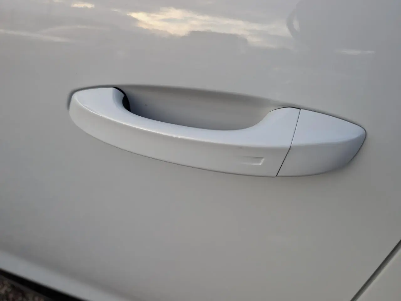 Poignée de porte blanche en gros plan sur la porte côté gauche du Peugeot 3008 Hybrid GT 2025.