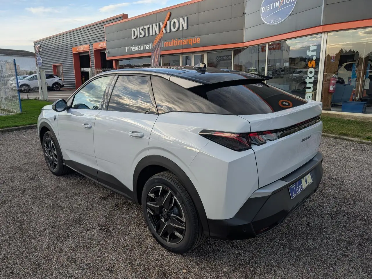 Peugeot 3008 blanc en vue 3/4 arrière droit, avec toit noir et jantes alliage 19'' noir brillant.