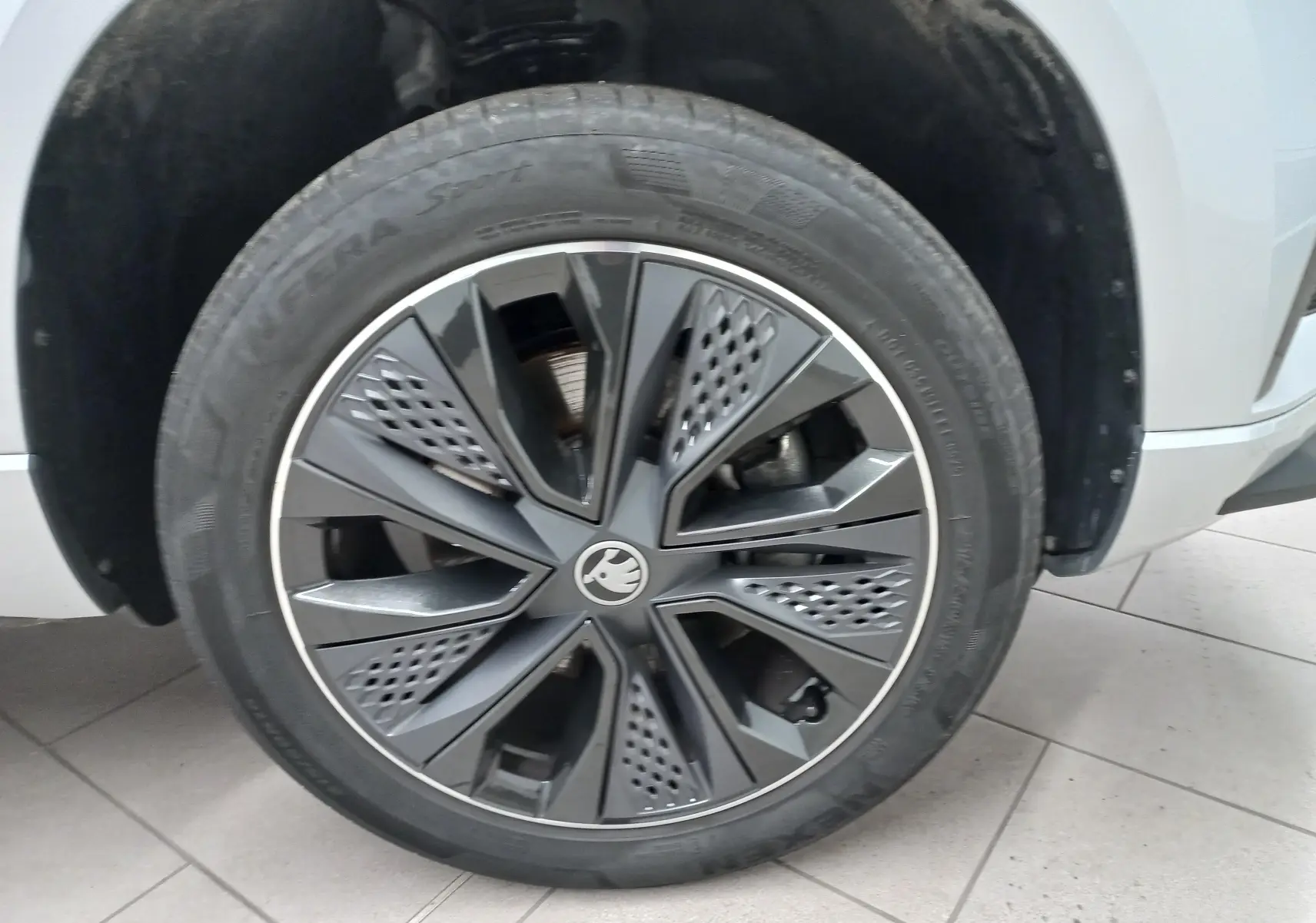 Gros plan sur la roue avant droite du Skoda Karoq gris argent, mettant en valeur la jante au design moderne.