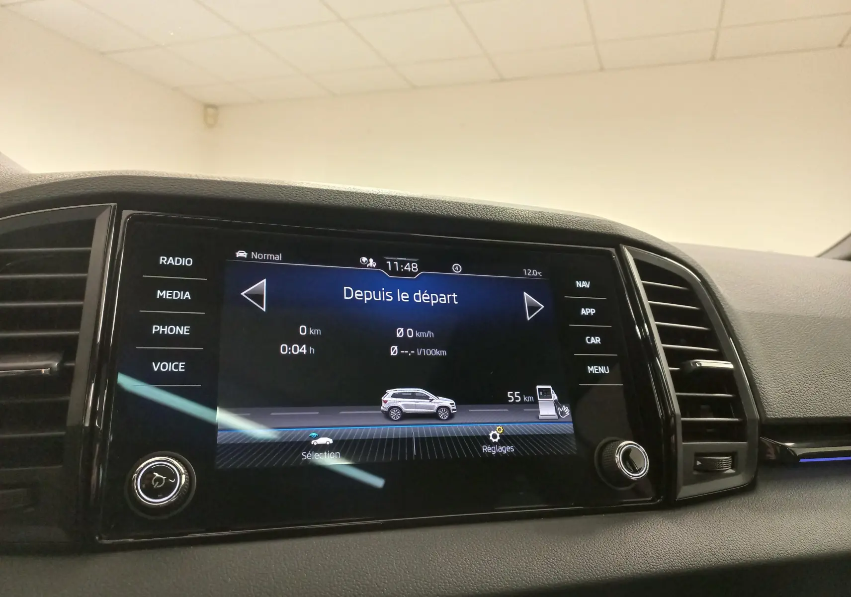 Écran tactile central du tableau de bord du Skoda Karoq 2025 affichant les données de trajet et les options de menu.