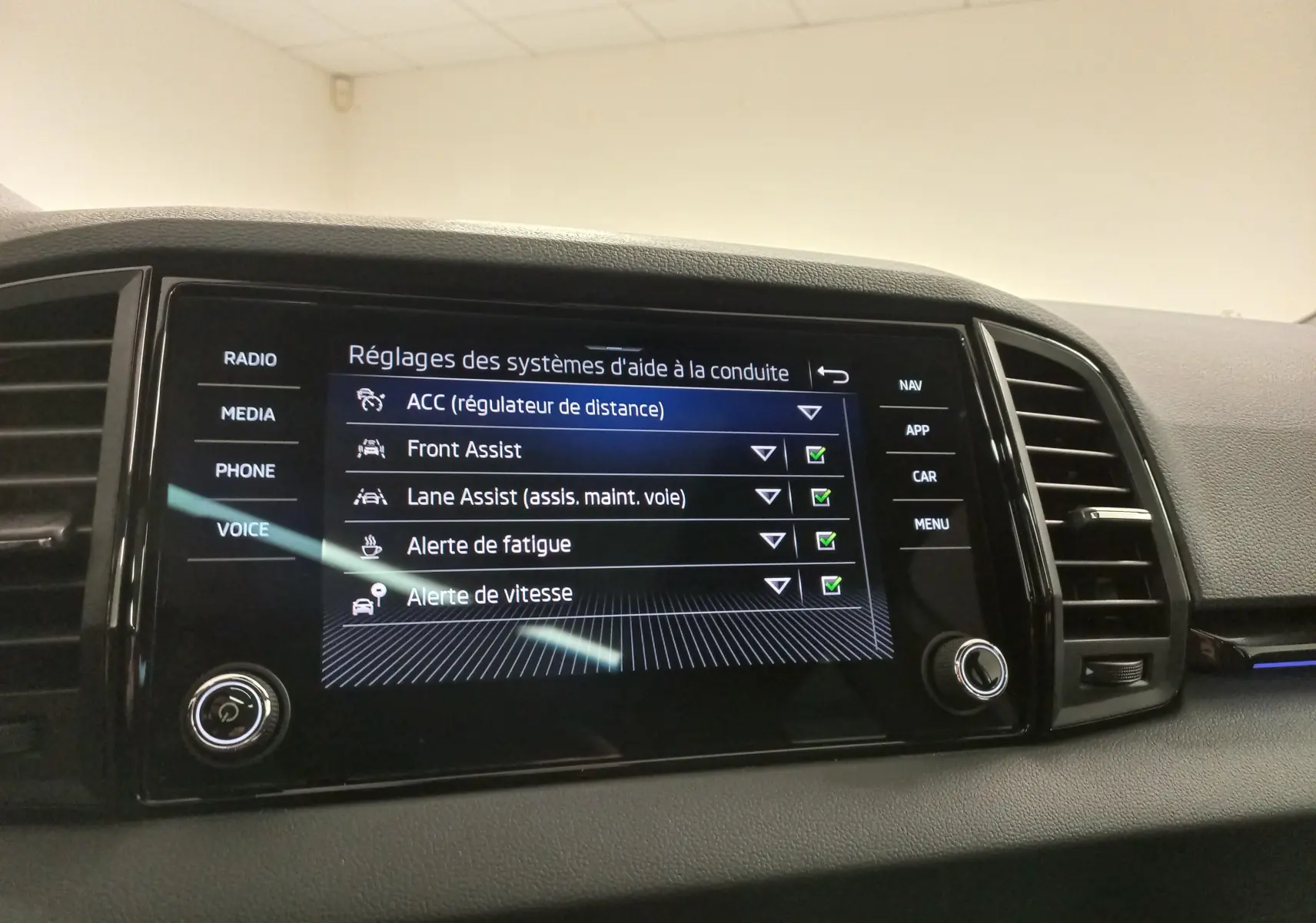 Écran tactile central du Skoda Karoq 1.5 TSI 2025 montrant les réglages des aides à la conduite.