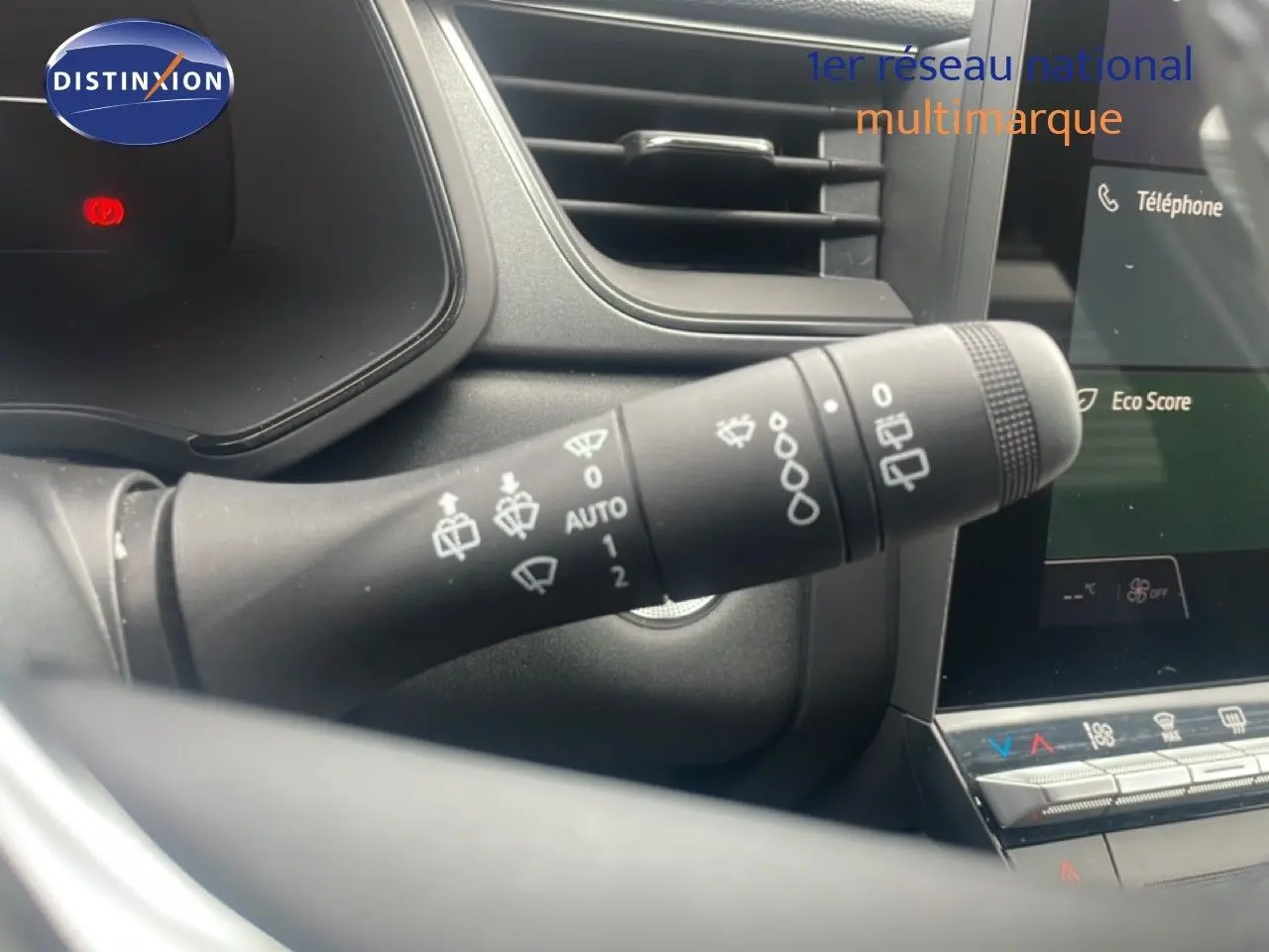 Gros plan sur la commande d'essuie-glace à gauche du volant dans l'habitacle du Renault Captur noir étoile métal avec toit gris.