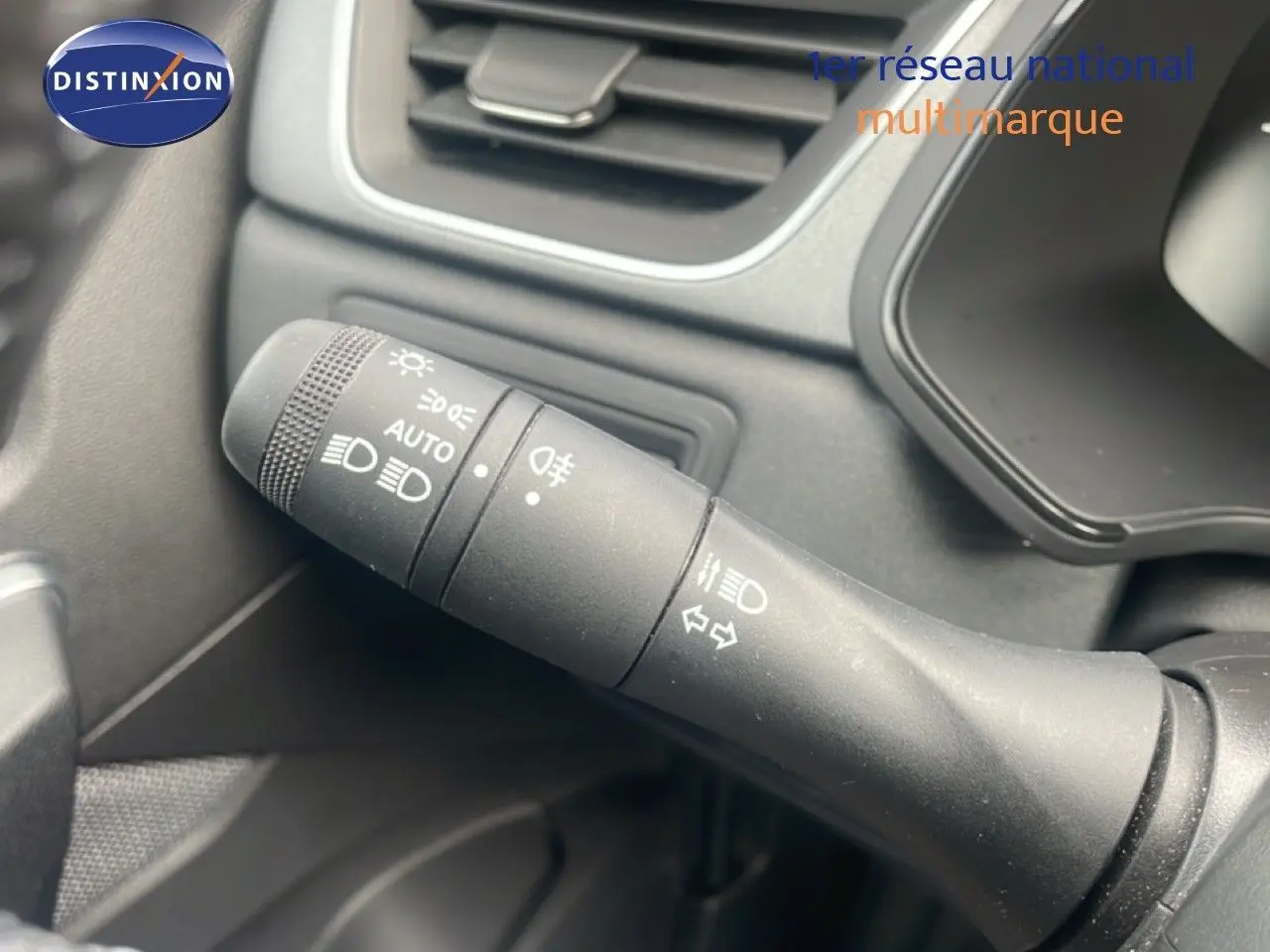 Gros plan sur la commande des phares et clignotants dans l’habitacle du Renault Captur noir étoile métal avec toit gris.