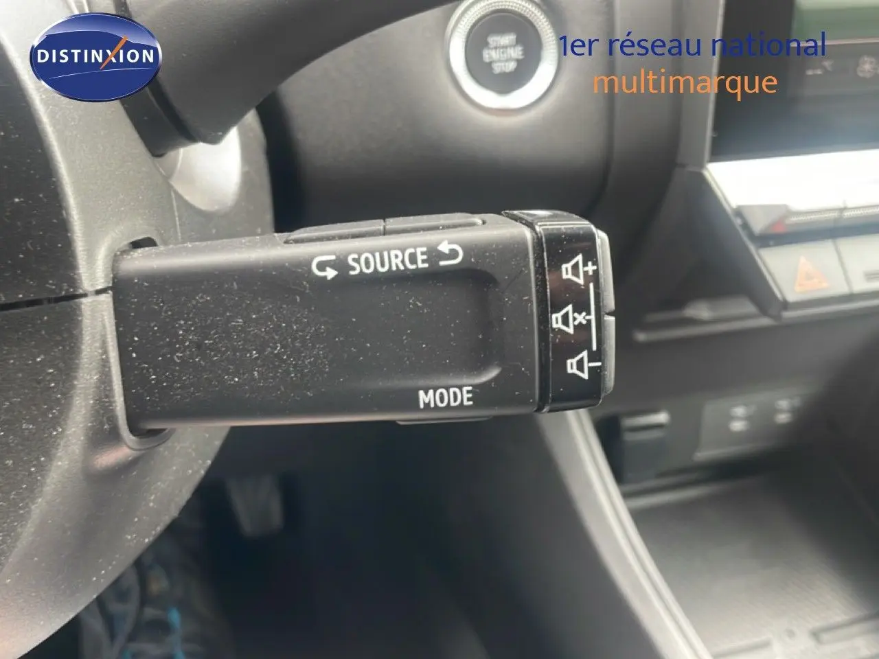 Gros plan sur la commande audio au volant du Renault Captur 2025 noir étoile métal avec toit gris, intérieur moderne.
