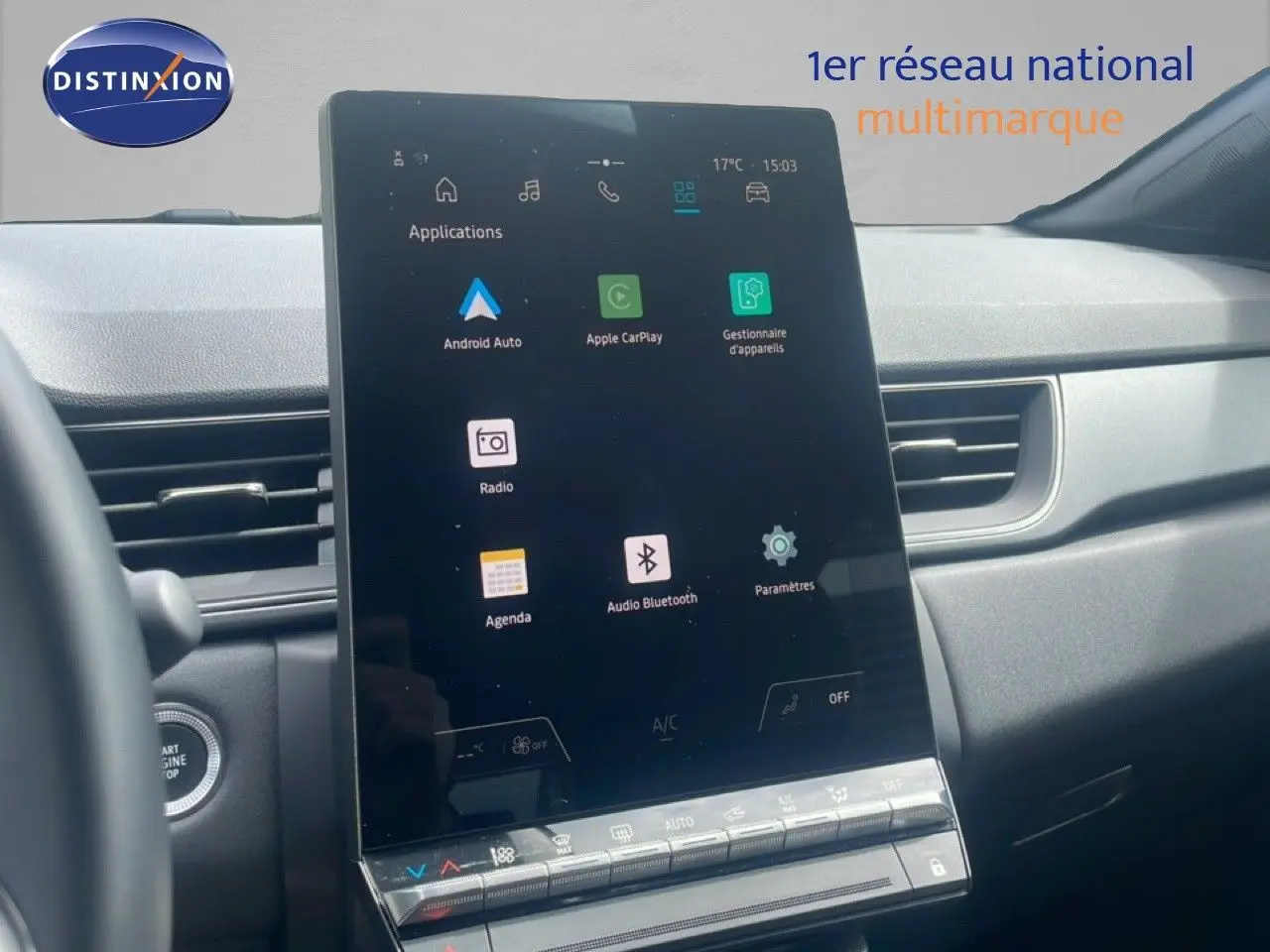 Vue intérieure centrée sur l'écran tactile vertical du tableau de bord du Renault Captur 2025, avec commandes climatisation visibles.