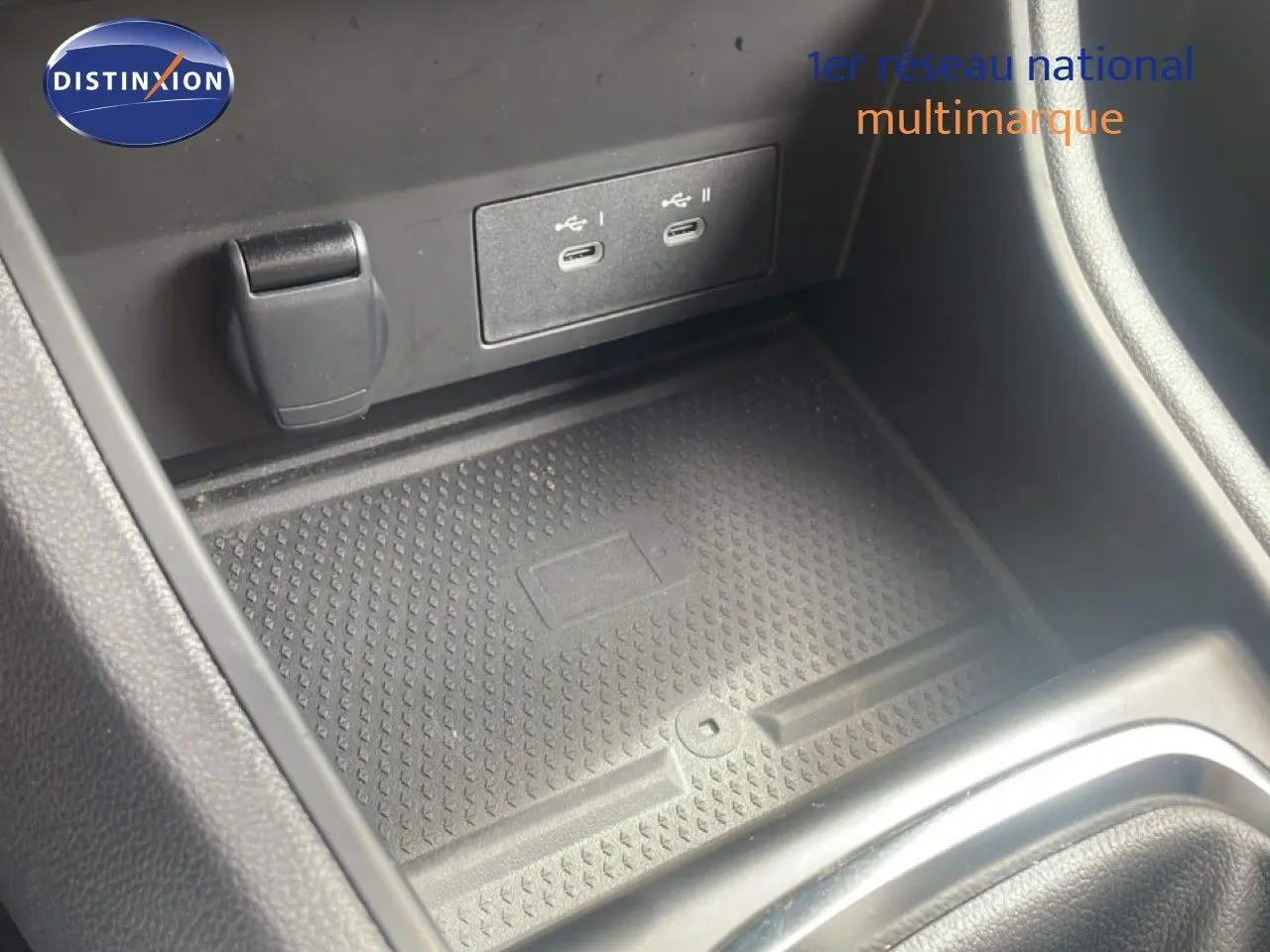 Gros plan sur la console centrale du Renault Captur 2025, montrant les ports USB et le tapis de rangement noir.