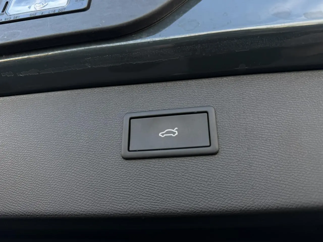 Bouton d'ouverture électrique du hayon sur la partie intérieure du coffre d'un CUPRA Formentor bleu Fjord.