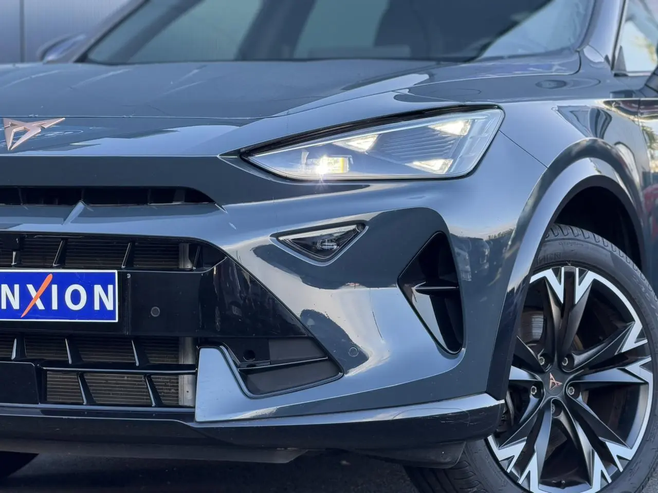Gros plan sur l'avant droit du CUPRA Formentor bleu Fjord, mettant en valeur ses phares Tri-LED et jantes alliage 18''.