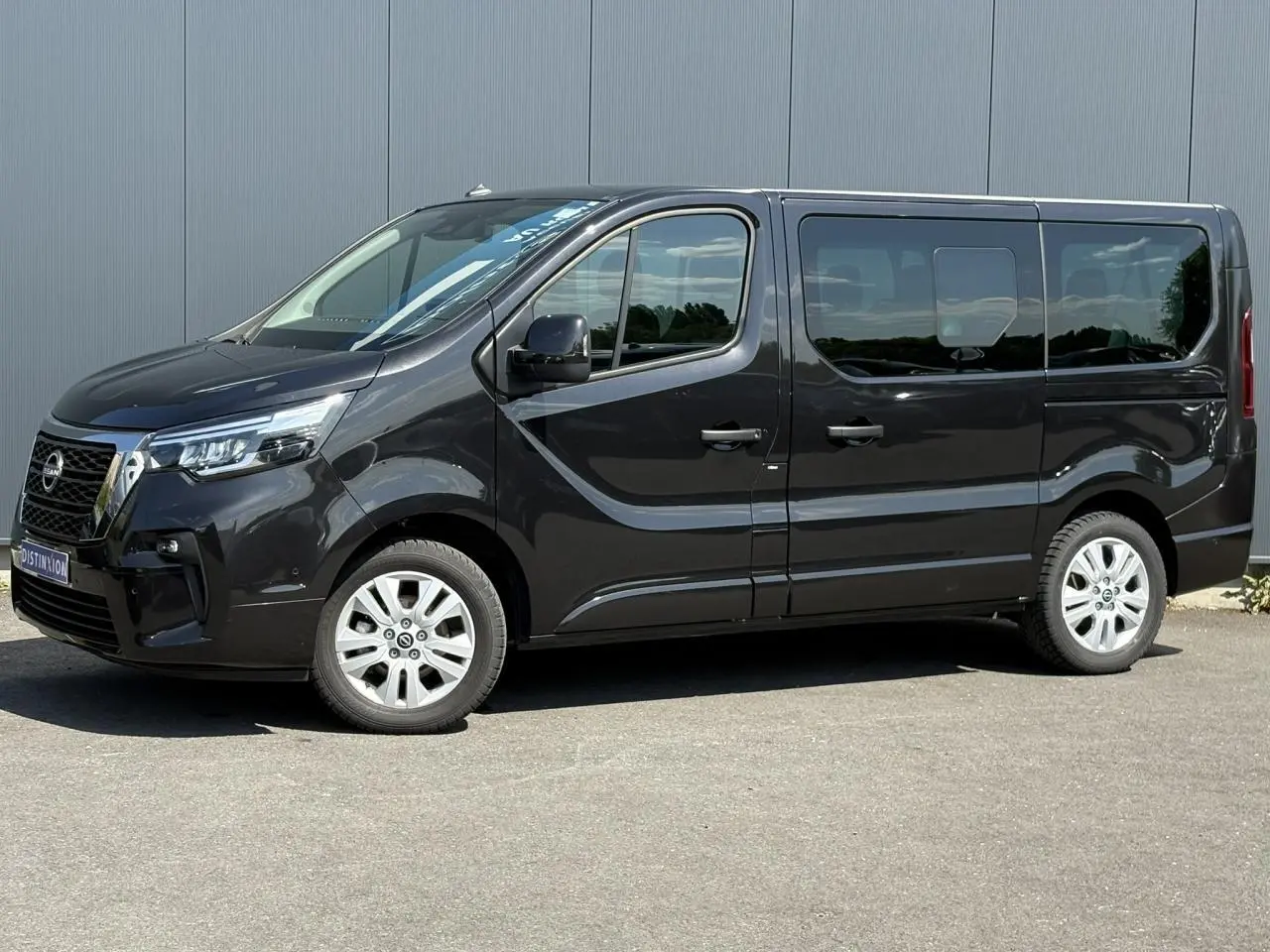 Vue de profil côté gauche du Nissan Primastar Combi noir Minuit avec portes latérales coulissantes et jantes alliage.