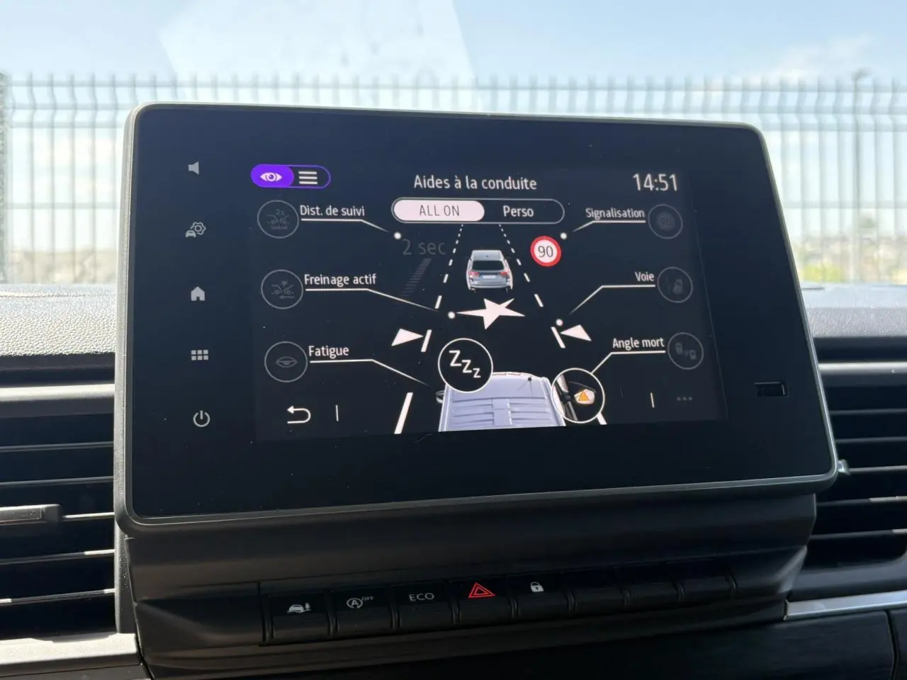 Écran tactile central affichant les aides à la conduite du Nissan Primastar Combi, vue intérieure frontale.
