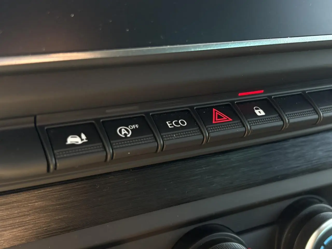 Gros plan sur les boutons de commande du tableau de bord noir du Nissan Primastar Combi 2025, avec bouton ECO et alerte.