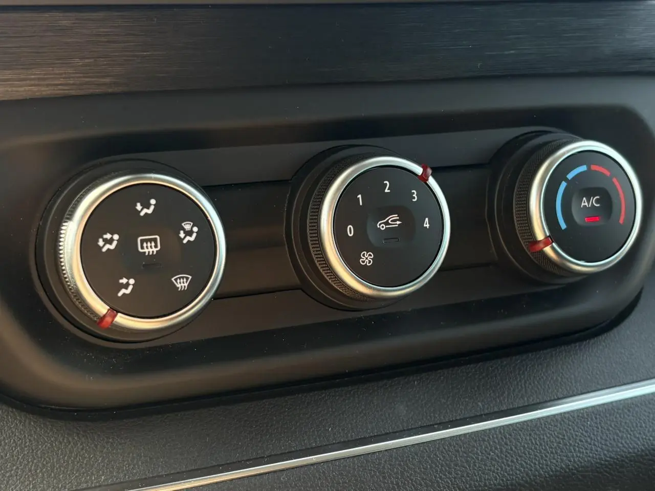 Gros plan sur les commandes de climatisation du Nissan Primastar Combi noir Minuit, avec réglages ventilation et A/C.