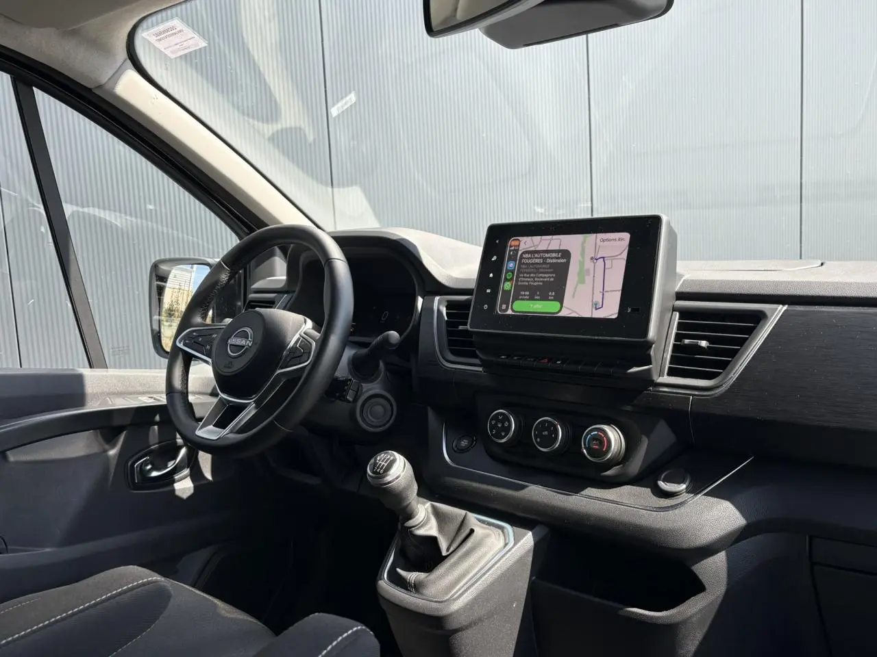 Vue intérieure côté conducteur du Nissan Primastar Combi 2025, tableau de bord avec écran tactile et boîte manuelle.