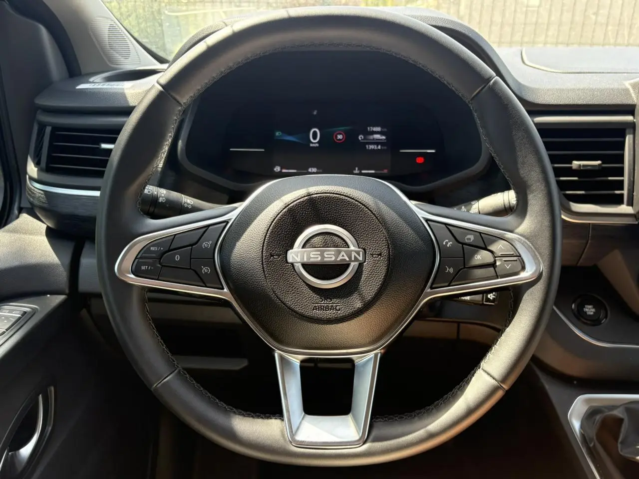 Vue rapprochée du volant noir de la Nissan Primastar Combi 2025 avec tableau de bord numérique et commandes au volant.