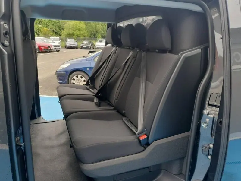 Vue intérieure côté droit sur la banquette arrière 3 places en tissu bi-ton noir/gris du Citroën Jumpy gris Titane 2025.