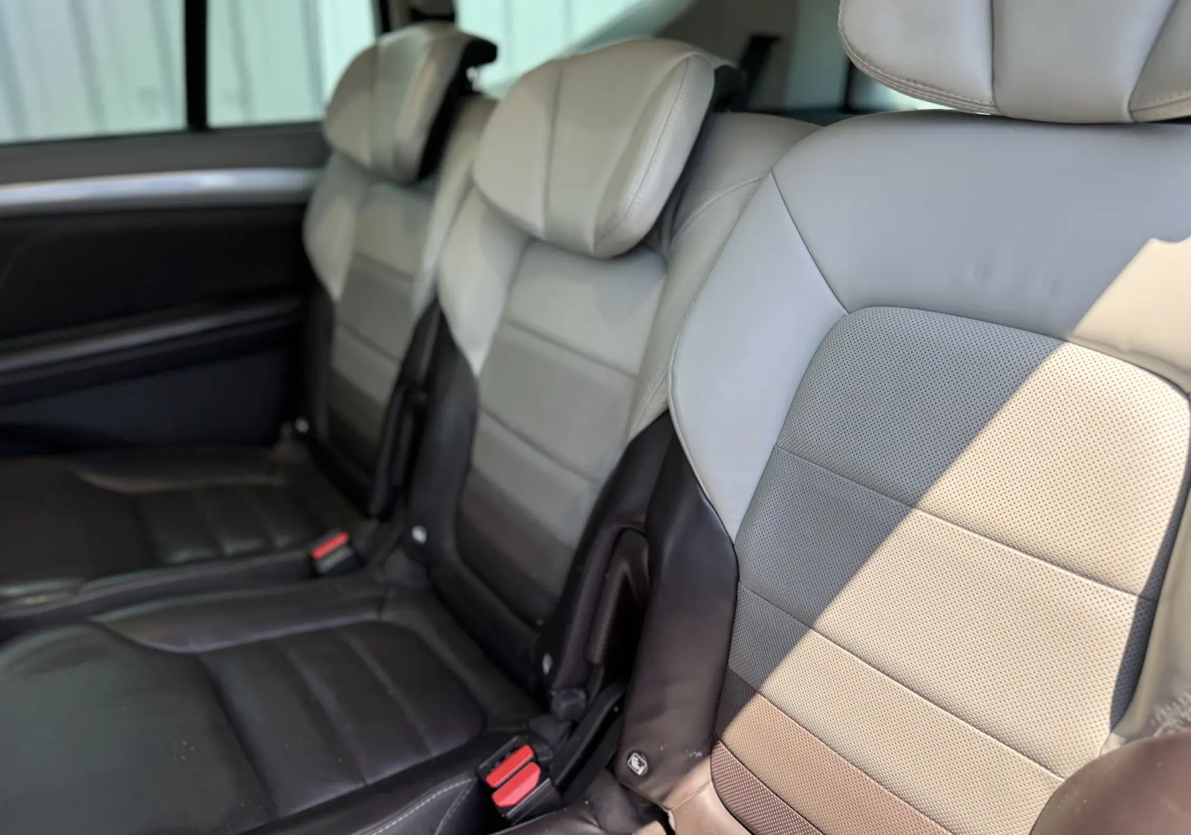 Vue intérieure rapprochée des sièges arrière en cuir bi-ton gris et noir du Renault Espace V 2017, version Initiale Paris.