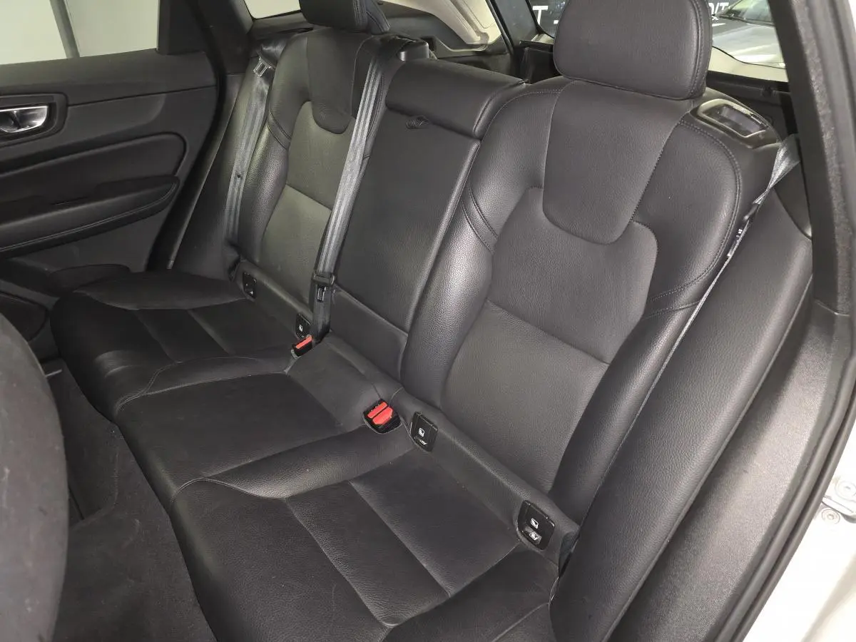 Vue intérieure du siège arrière en cuir noir du Volvo XC60 2023, côté droit avec ceintures de sécurité visibles.