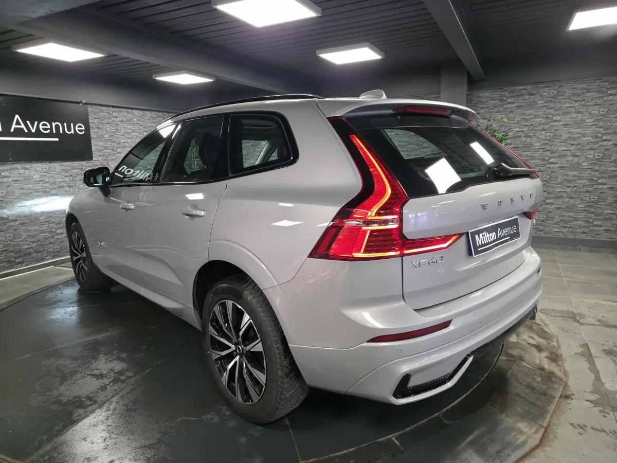 Vue 3/4 arrière droit du Volvo XC60 gris métallisé avec feux arrière LED en forme de L et jantes alliage noires.