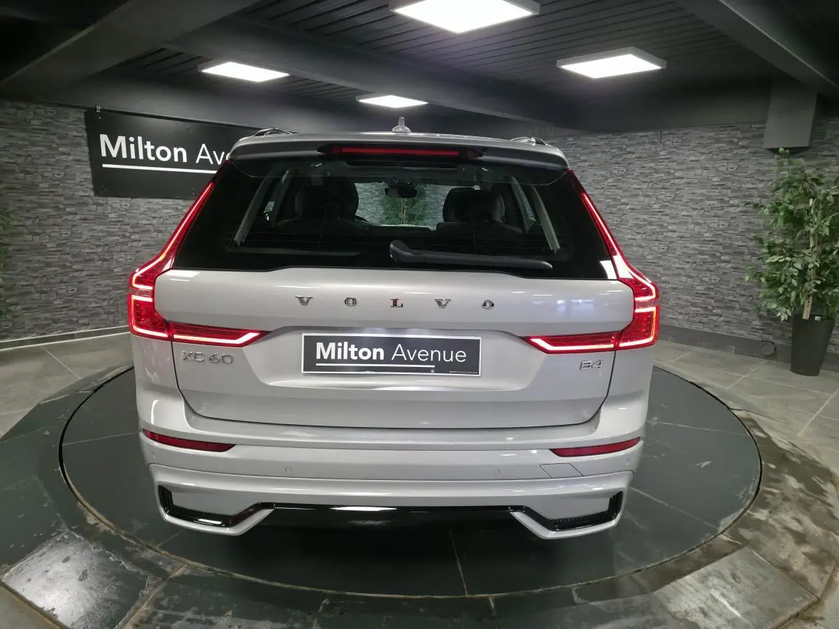 Vue arrière d'un Volvo XC60 gris métallisé avec feux LED en forme de C et double sortie d'échappement intégrée.