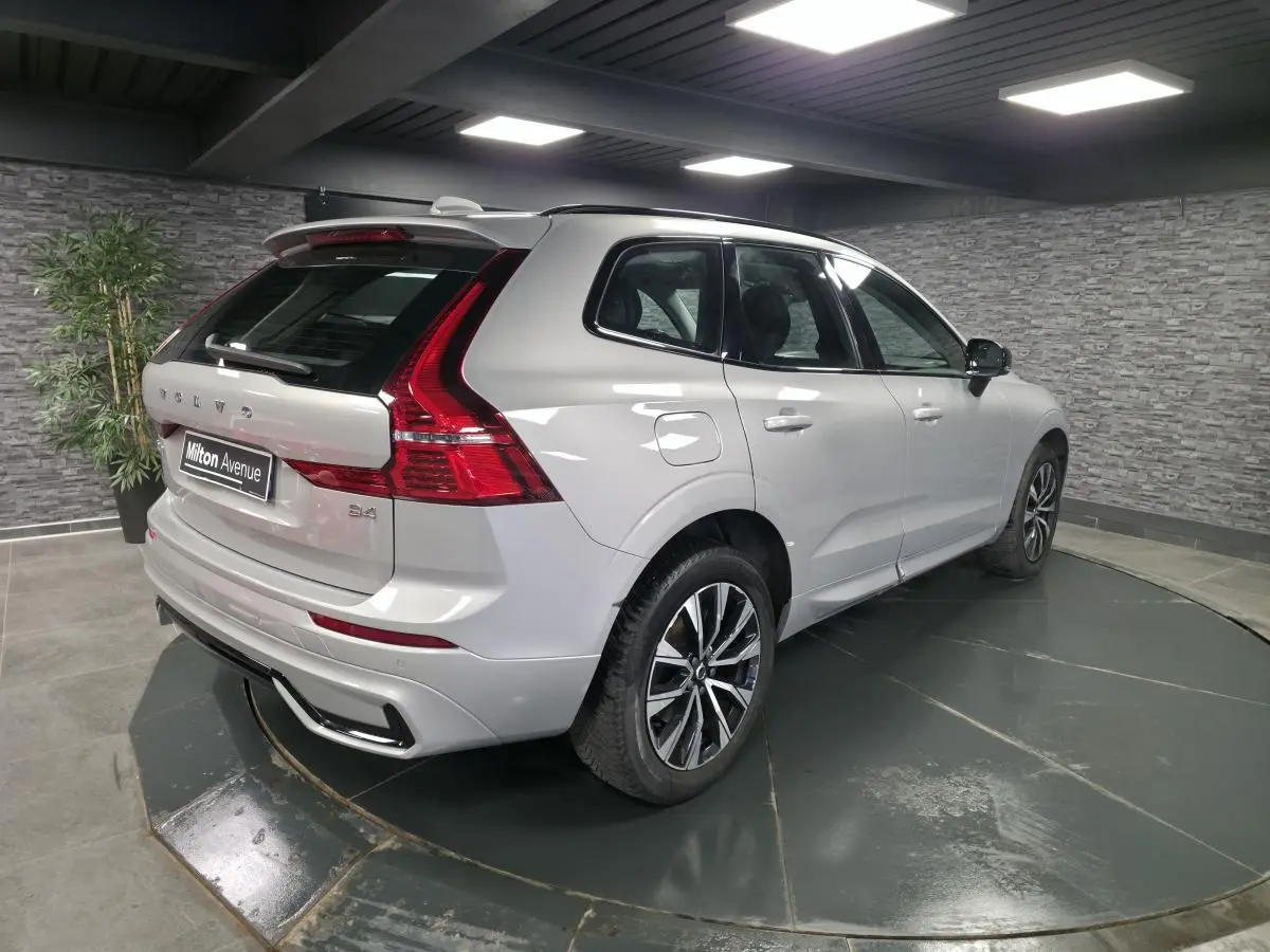 Vue 3/4 arrière droite d'un Volvo XC60 gris métallisé avec jantes alliage noires et inserts noir laqué.