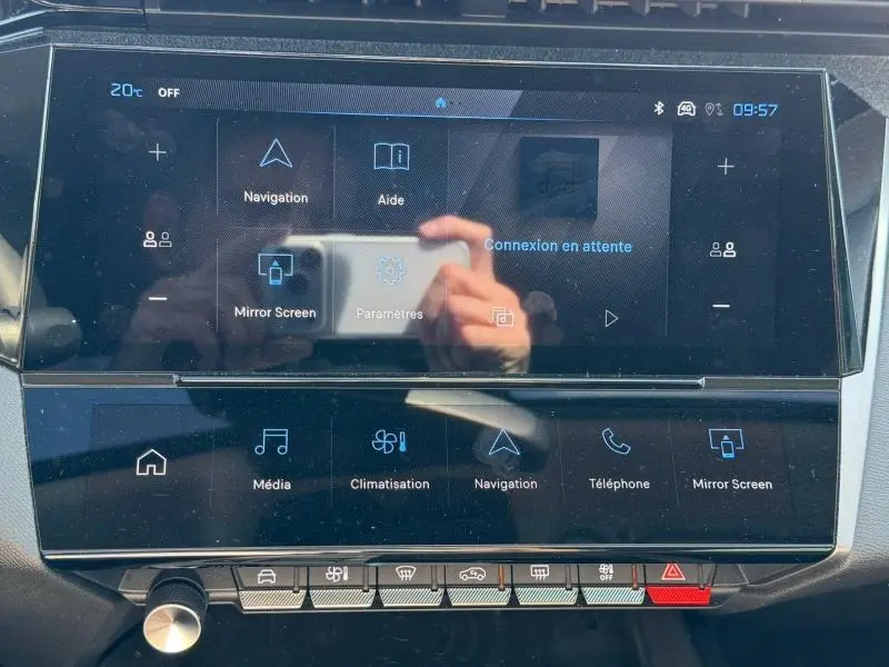 Vue rapprochée de l'écran tactile central multifonction noir du Peugeot 308 Hybrid 2025 avec commandes numériques et boutons physiques.