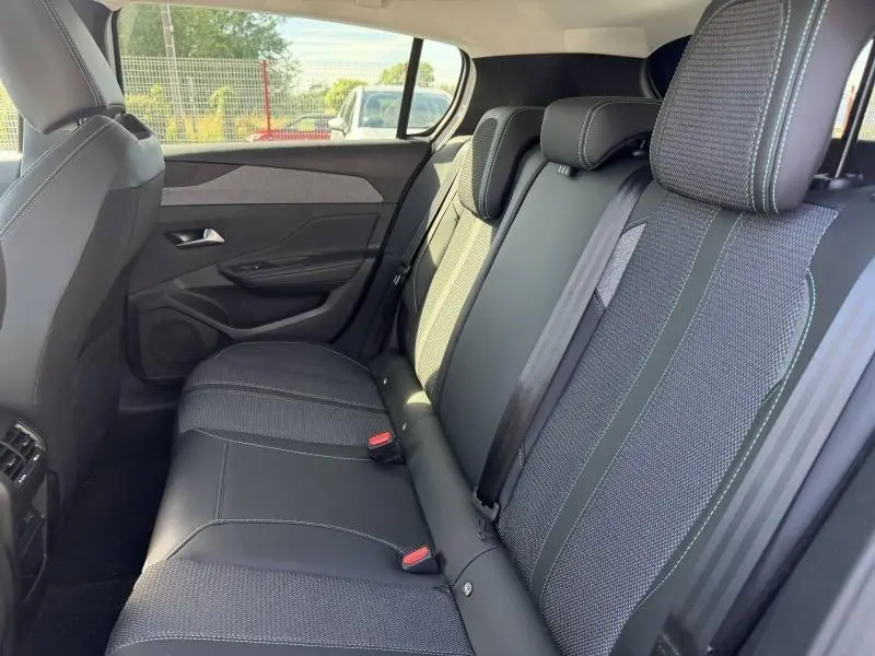 Vue intérieure côté droit des sièges arrière en tissu et cuir noir de la Peugeot 308 Hybrid 2025.
