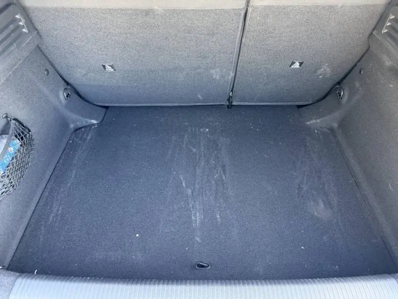 Coffre vide vu de face du Peugeot 308 Hybrid blanc Okénite, avec revêtement intérieur noir et filet latéral.