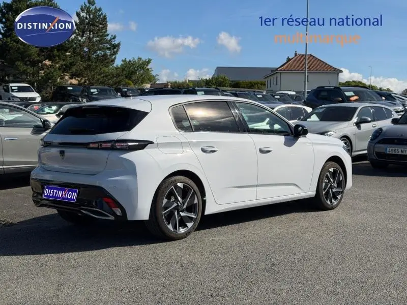 Peugeot 308 Hybrid blanc Okénite vue 3/4 arrière droit, jantes alu et feux arrière LED distinctifs.