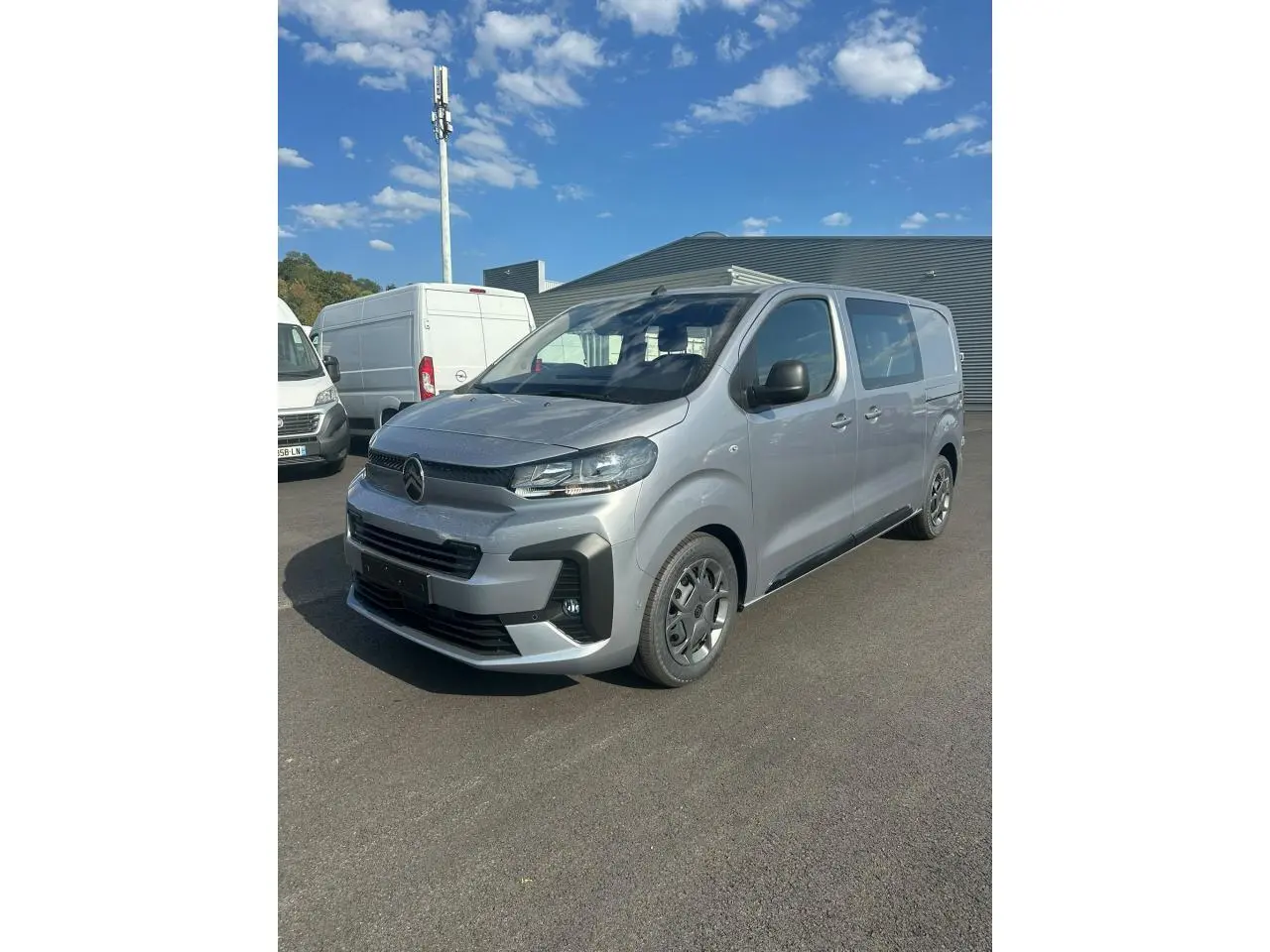 Citroën Jumpy gris Artense vu en 3/4 avant droit avec projecteurs modernes et jantes tôles noires.
