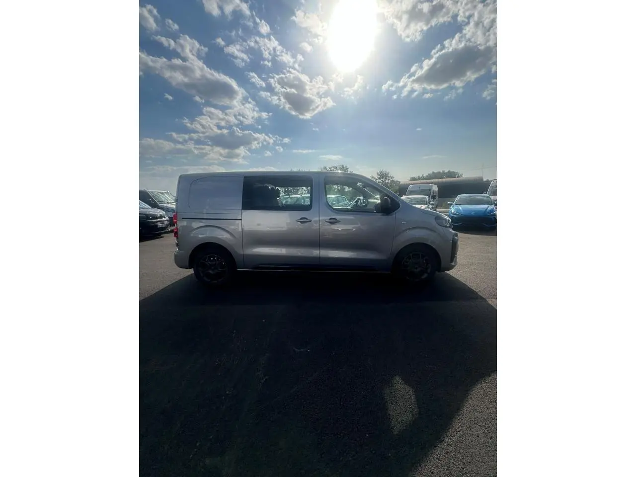 Vue de profil côté gauche d'un Citroën Jumpy gris Artense avec porte latérale coulissante et jantes noires.