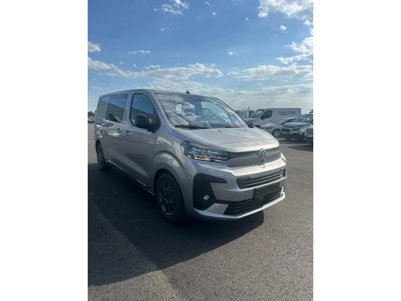 Vue 3/4 avant droit du Citroën Jumpy gris Artense avec jantes noires et boucliers couleur carrosserie.