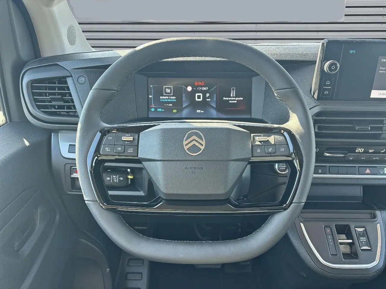 Vue intérieure centrée sur le volant en cuir noir du Citroën Jumpy 2026 avec tableau de bord digital et commandes intégrées.