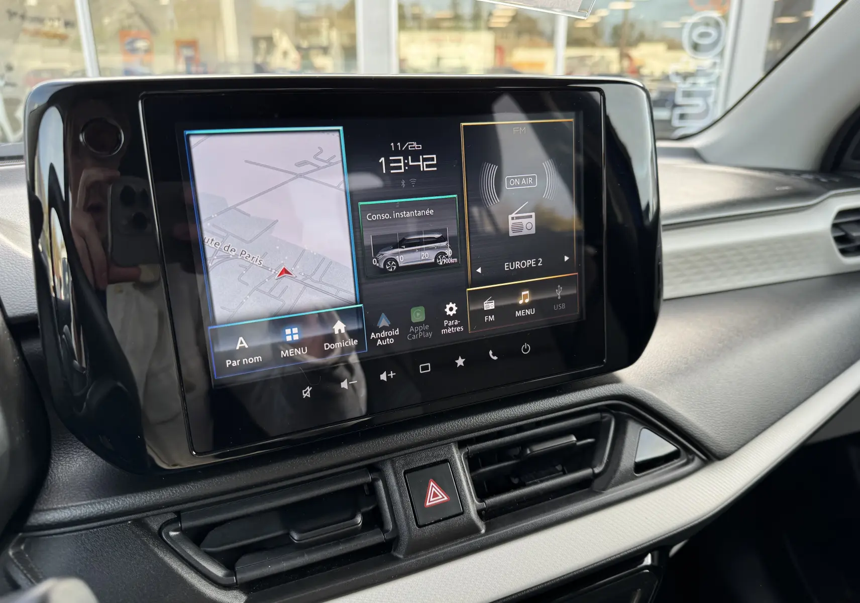 Écran tactile central du tableau de bord de la Suzuki Swift 1.2 Hybrid Privilege Auto 2025, affichant navigation et radio.