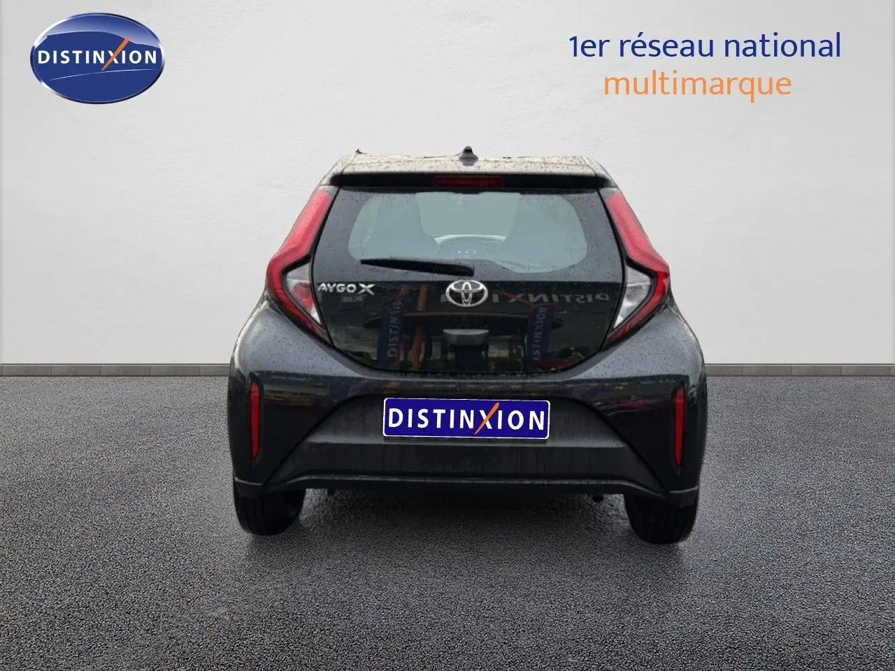 Vue arrière d'une Toyota Aygo X noire 2025, mettant en valeur ses feux arrière distinctifs en forme de C.