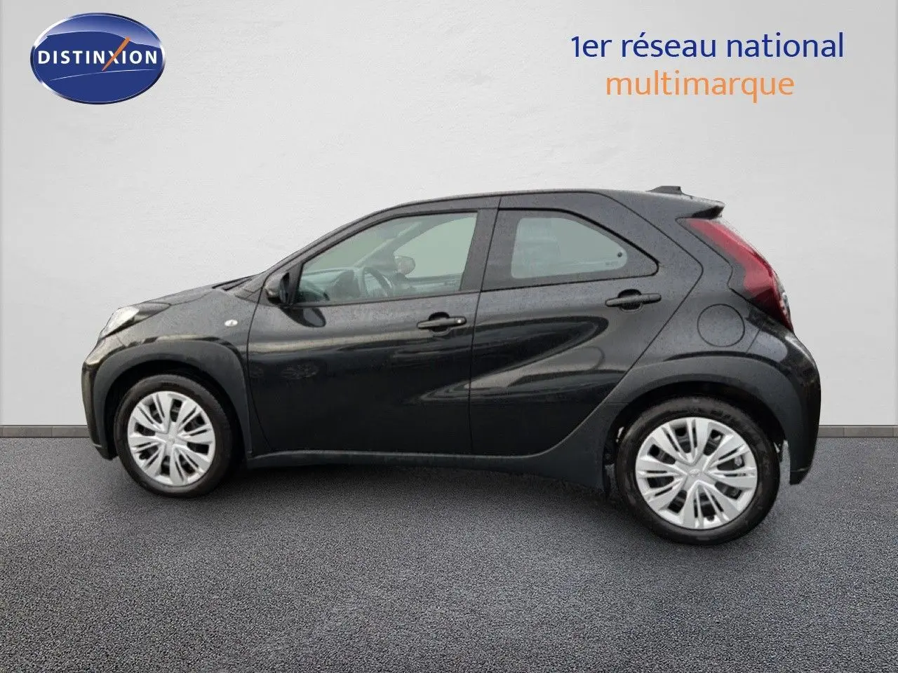 Profil côté gauche de la Toyota Aygo X 1.0 72CH Dynamic noire 5 portes, avec jantes argentées et lignes fluides.
