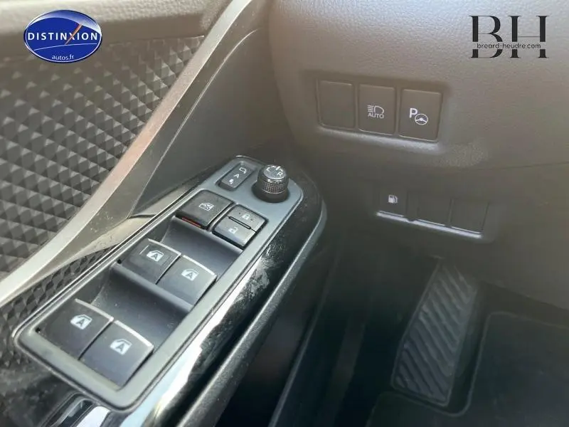 Vue rapprochée du panneau de commandes des vitres et rétroviseurs côté conducteur du Toyota C-HR blanc nacré 2019.