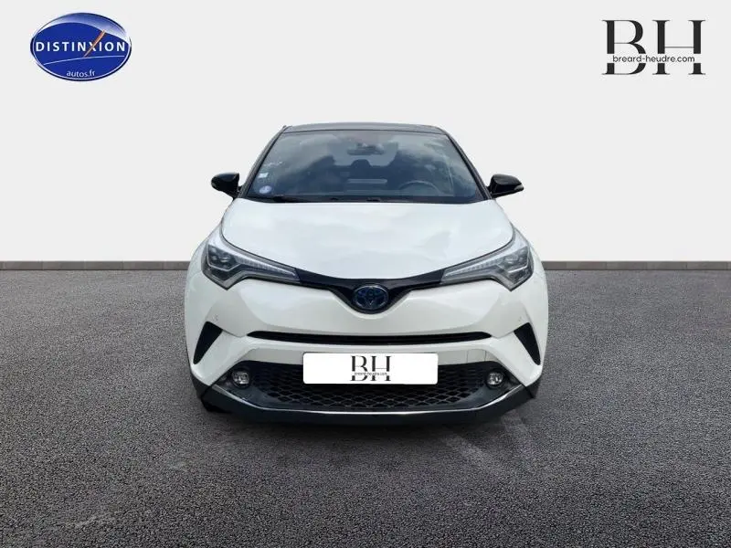 Vue avant d'un Toyota C-HR 122h Collection 2WD blanc nacré bi-ton avec phares LED et calandre noire distinctive.